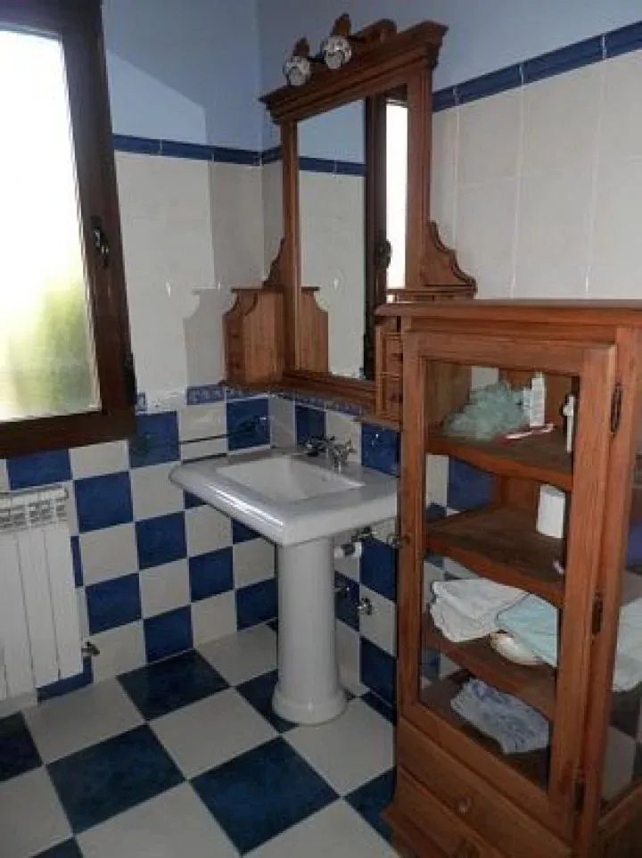 Baño con azulejos azules y mueble de madera