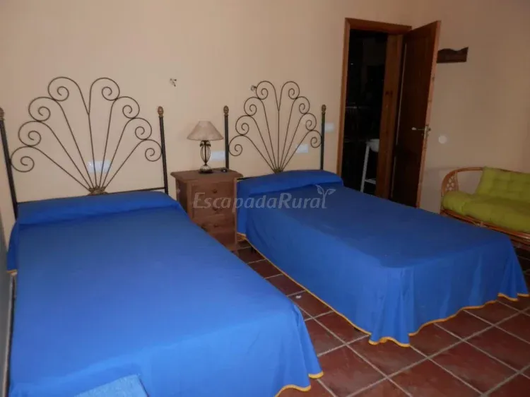 Dormitorio con dos camas y colchas azules