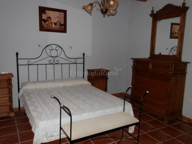 Dormitorio con cama de forja blanca