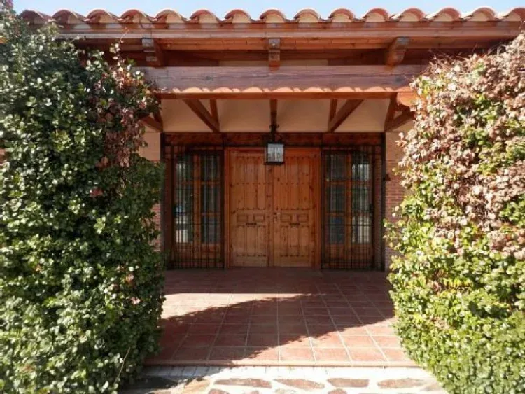 Fachada de la casa con parra roja en la entrada