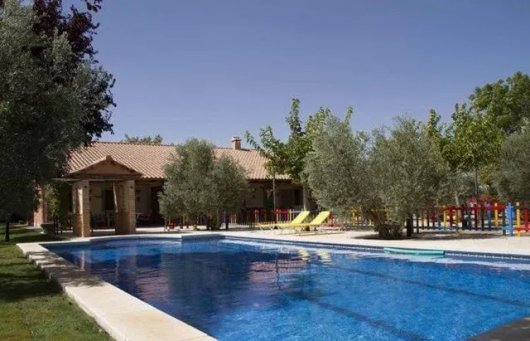 Piscina con la casa y los olivos al fondo