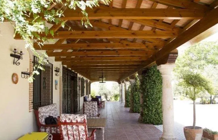 Porche con pérgola de madera y mesa larga